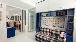 Un soggiorno moderno con colori blu e bianchi, un divano a quadri e una parete decorata con oggetti ornamentali.