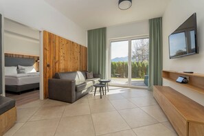 A modern room with a bed, sofa, and a TV.