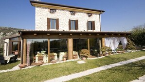 A two-story stone building with a covered patio area. - Villa Gesi - Apartment 3 (Negrar)