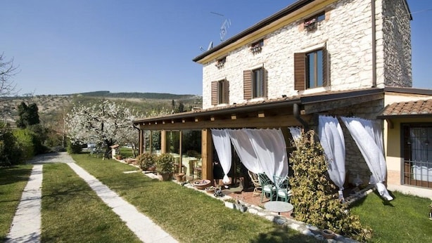 A stone house with a covered patio, a lawn, and a view of the hills. - Villa Gesi - Apartment 3 (Negrar)