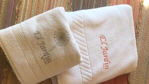 Three folded white towels with embroidered text on them.