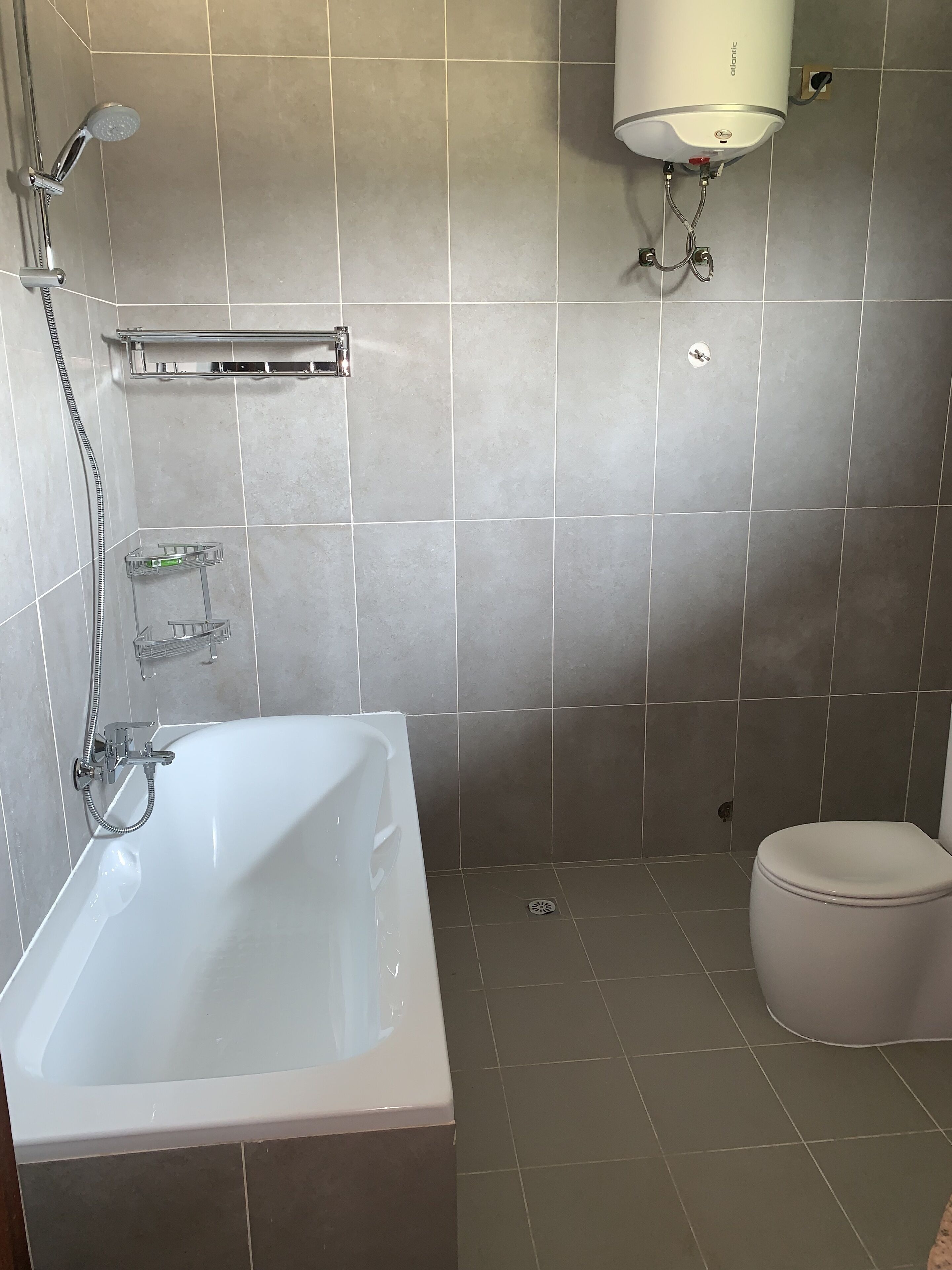 A bathroom with a bathtub, a toilet, and a shower.