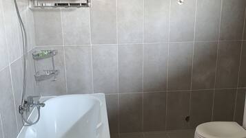 A bathroom with a bathtub, a toilet, and a shower.