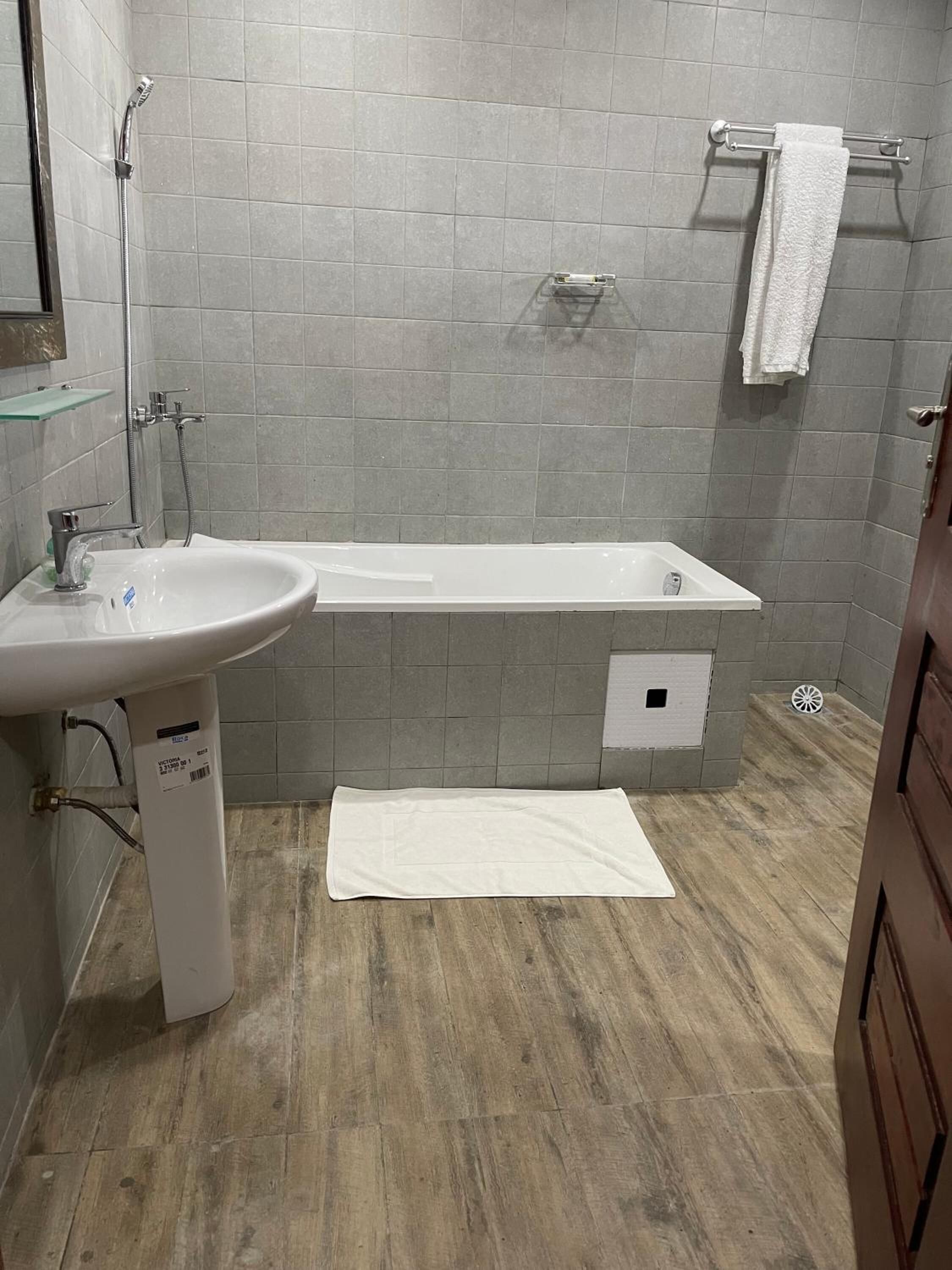 Une salle de bain équipée d’un lavabo, d’une douche et d’un porte-serviettes.