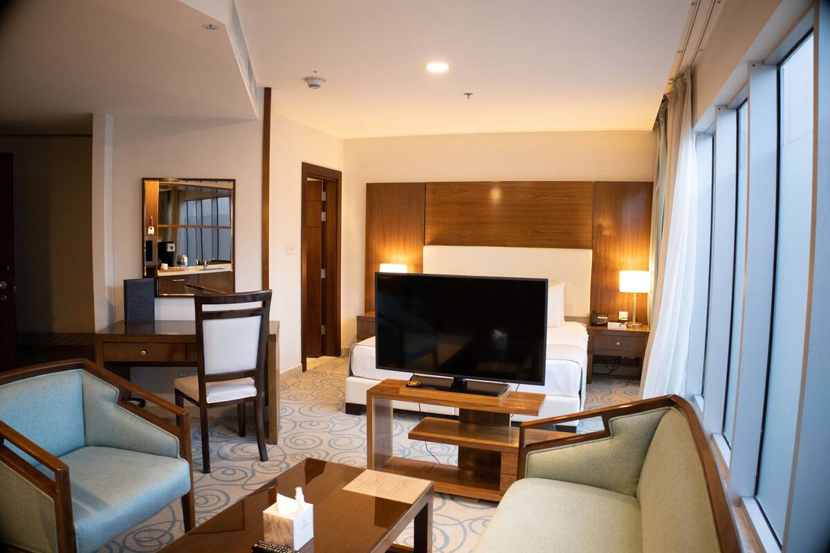 Une chambre d’hôtel équipée d’une télévision, d’un canapé, d’un bureau et d’une chaise.