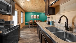 A kitchen with wooden cabinets, a granite countertop, and a stainless steel sink.