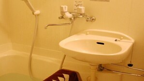 Ein Badezimmer mit einer Badewanne, einem Waschbecken und einem Handtuch mit dem Aufdruck 'Matsue City Hotel'.