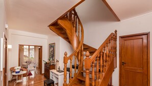 A wooden staircase with a curved design leading to a door. - Fonte Branca Guest House (Braga)