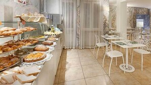 A buffet area with various food items and white chairs. - Mastino Rooms (Verona)