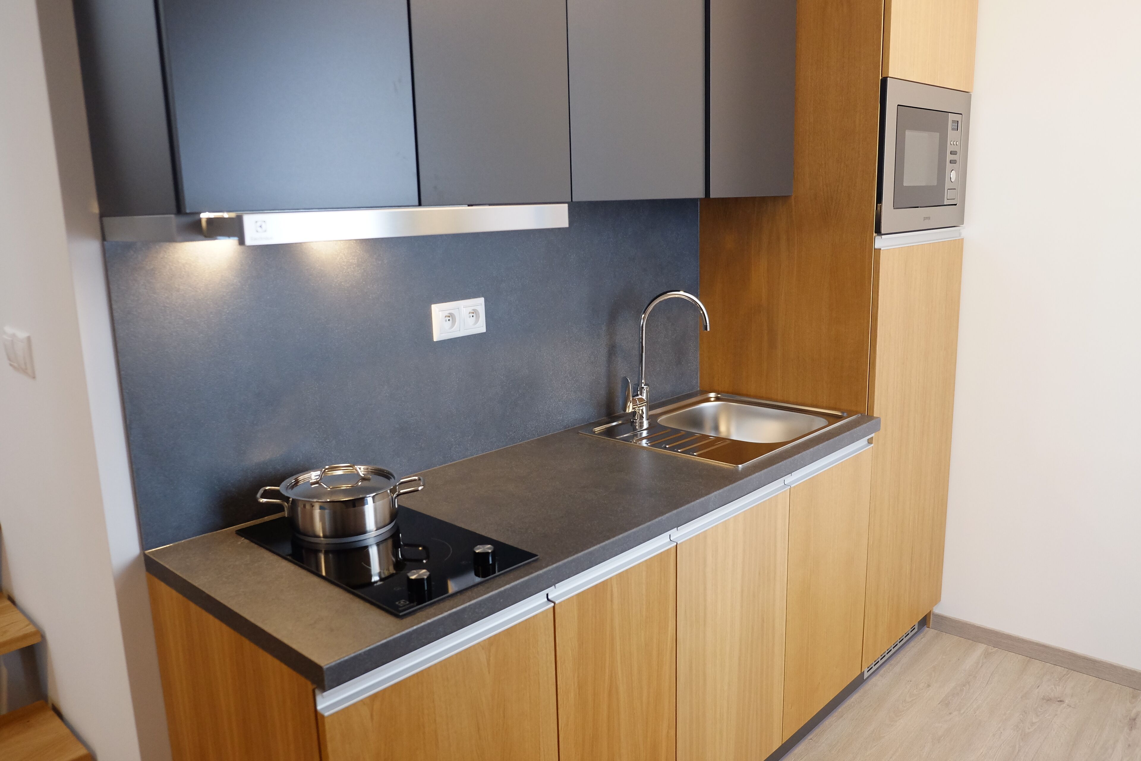 Una cocina moderna con estufa integrada, lavaplatos y microondas.