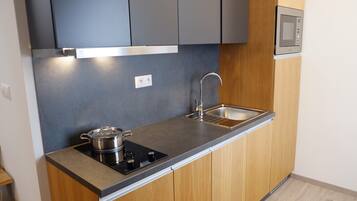 Una cocina moderna con estufa integrada, lavaplatos y microondas.