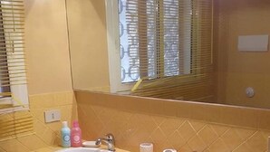 A bathroom with two sinks, a mirror, and a window with blinds. - Villa Pomelia a stone's throw from the sea (Palermo)