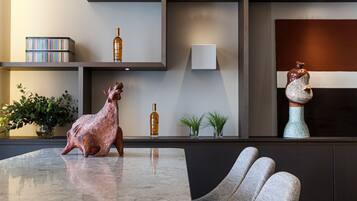 Un intérieur moderne avec une table en marbre, une sculpture et une plante en pot.