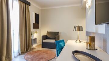 Un salon moderne avec un canapé, une table basse, une lampe et un téléviseur à écran plat fixé au mur.