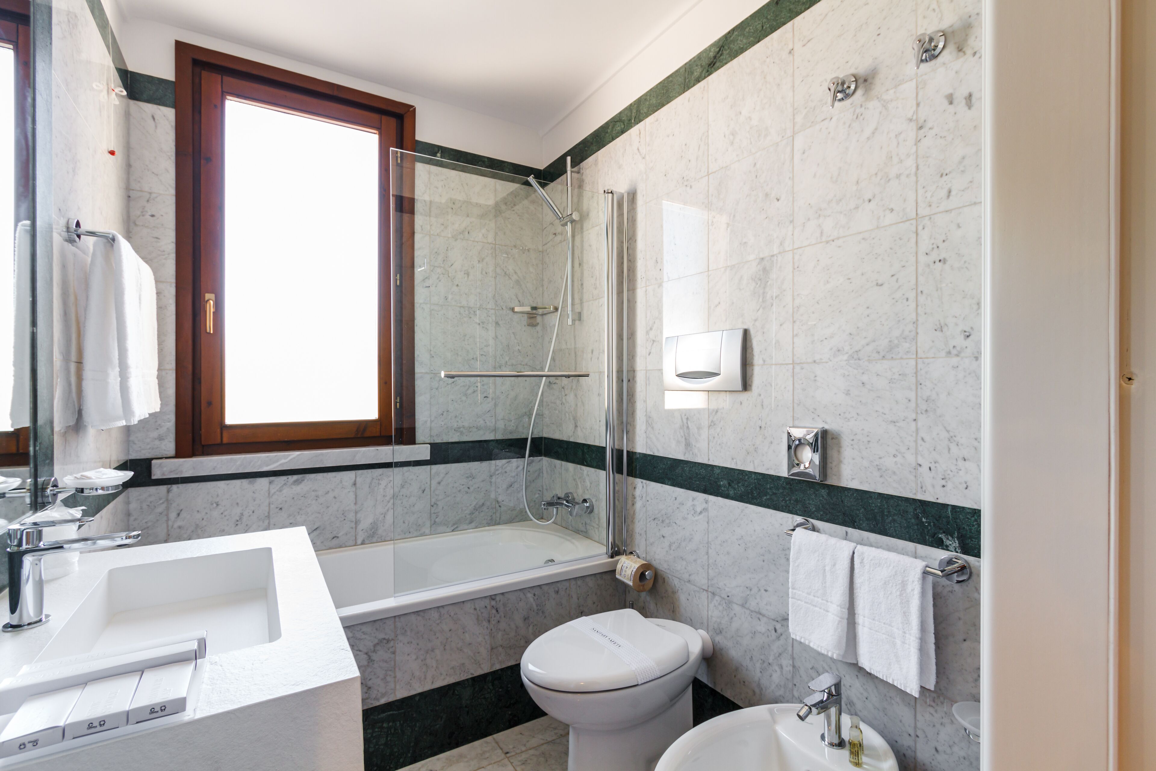 A modern bathroom with a bathtub, toilet, and sink.
