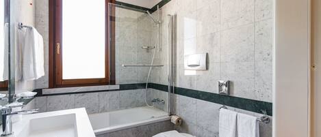 A modern bathroom with a bathtub, toilet, and sink.