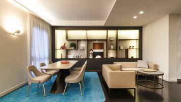 A modern living room with a dining area, a sofa, a coffee table, and a TV.