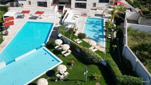 A hotel with multiple swimming pools, sun loungers, and a view of the sea. - SEAWATER HOTEL BIO & BEAUTY SPA  (Marsala)