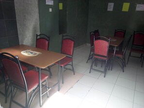 A room with several tables and chairs, some with menus. - Canary Guest House (Matuu)