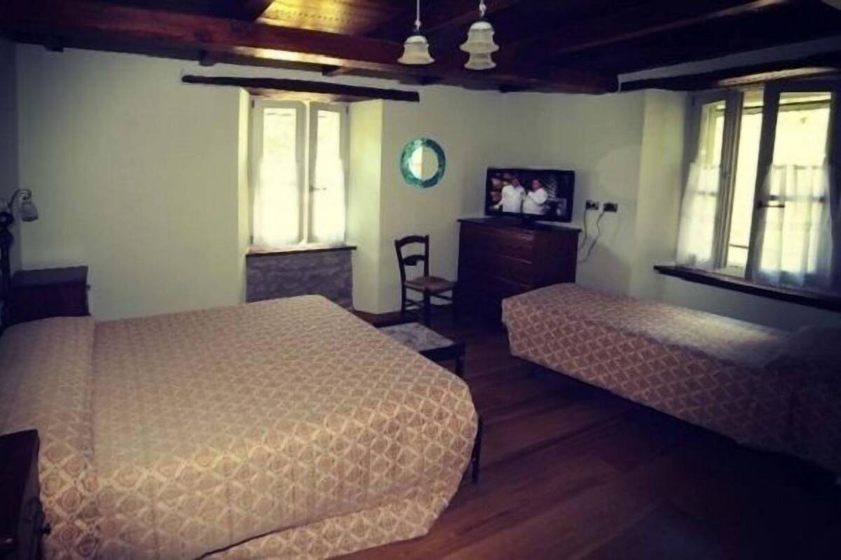 Habitación con dos camas, televisión y ventana.
