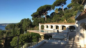 Un edificio bianco con finestre ad arco e una zona piscina.
