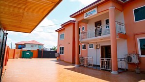 A two-story building with a balcony and a sign that reads "elmay's Haven". - Mays Haven (Taifa)