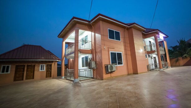 A two-story building with a balcony on the second floor, a covered entrance, and a tiled ground floor. - Mays Haven (Taifa)