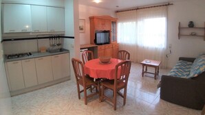 A compact living space with a kitchen, dining area, and a sofa. - Colera Apartment A costa brava (Colera)