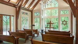 A church interior with wooden pews, stained glass windows, and a Star of David on the wall. - Luxurious Villas in the Blue Ridge Mountains. (Cashiers)