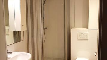 Een douche, handdoeken, zeep, toiletpapier