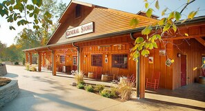 A wooden general store with a covered porch and outdoor seating.