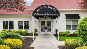 A building with a sign reading "Suites At Hershey Clubhouse & Registration 'Sweet Escape'".