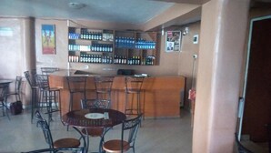 A restaurant with a bar area, tables, and chairs. - Sirlo Hotel (Thika)