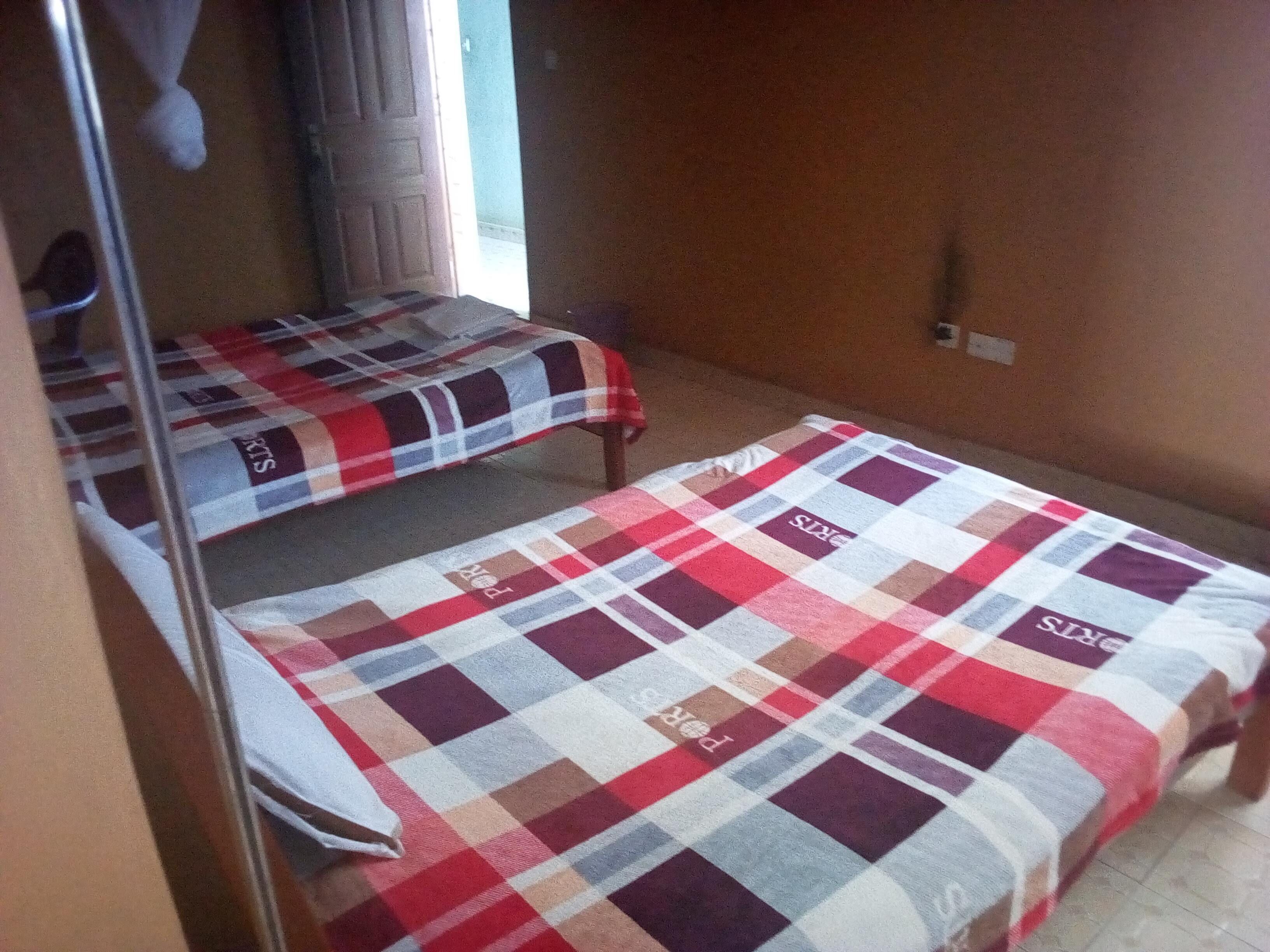 Una habitación con dos camas, cada una cubierta con una manta escocesa.