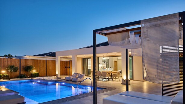 A modern outdoor pool area with a glass enclosure, seating, and a dining area. - Private pool Villa with sea view at 250 m from the sea/beach (zakynthos)