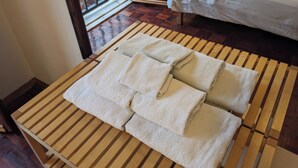 Ordentlich platzierte Handtücher auf einem Holztisch in einem Hotelzimmer.