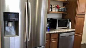 A kitchen with stainless steel appliances, wooden cabinets, and a countertop microwave. - Big Bend Getaway..... (Alpine)