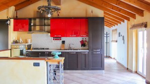 A spacious kitchen with high ceilings, a central island, and modern appliances. - Sunshine apartment - terrace in Acquaseria (Acquaseria)