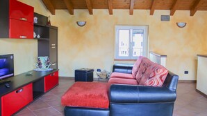 A living room with a sofa, a TV, and a red cabinet. - Sunshine apartment - terrace in Acquaseria (Acquaseria)