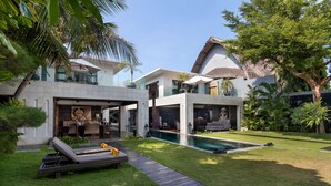 A modern house with a swimming pool, a covered outdoor seating area, and lush greenery. - 5 Bedroom Holiday Villa in Seminyak with Private Pool, Bali Villa 2001 (Bali)