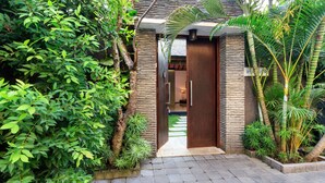 A pathway leading to a modern building with a stone facade and a door.