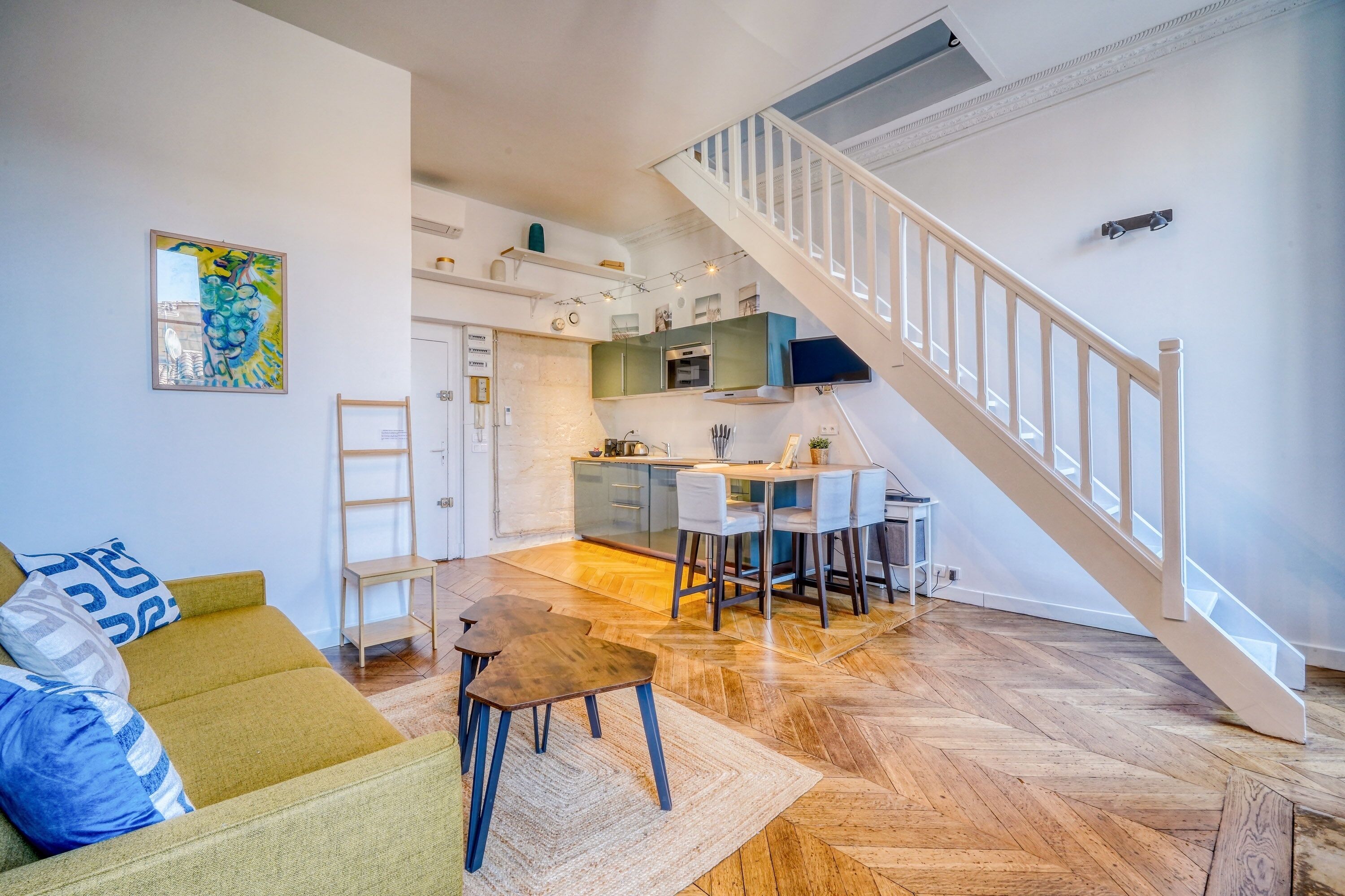 Een modern appartement met een eethoek, keuken en een trap.
