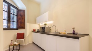 Una cocina moderna con isla integrada, muebles blancos y una ventana con vidrio esmerilado.