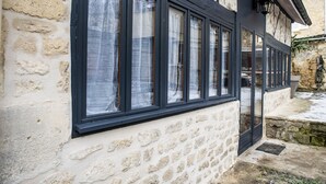 A stone building with multiple windows and a black awning.