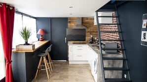 A modern kitchen with a built-in stove, a coffee machine, and a washing machine.