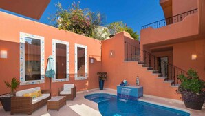 A pool area with a curved pool, outdoor furniture, a staircase, and a potted plant. - Casa Bella 2BR by Casago (Loreto)
