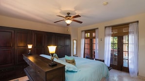 A bedroom with a bed, bedside lamps, a ceiling fan, and a wooden dresser. - Casa Bella 2BR by Casago (Loreto)