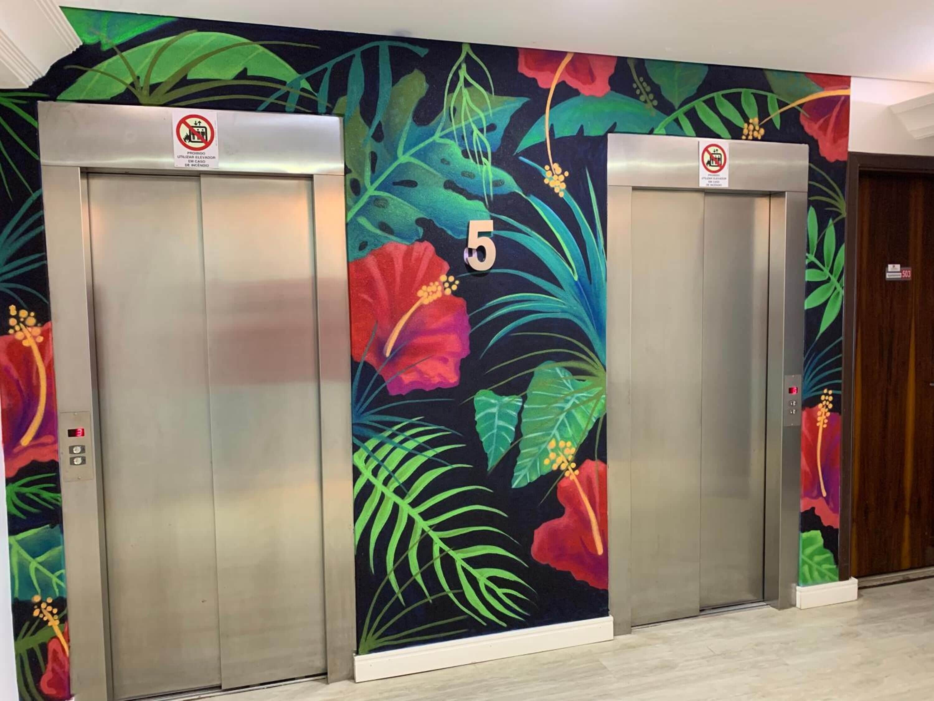 Two elevators with floral wall art and a number 5 on the wall.