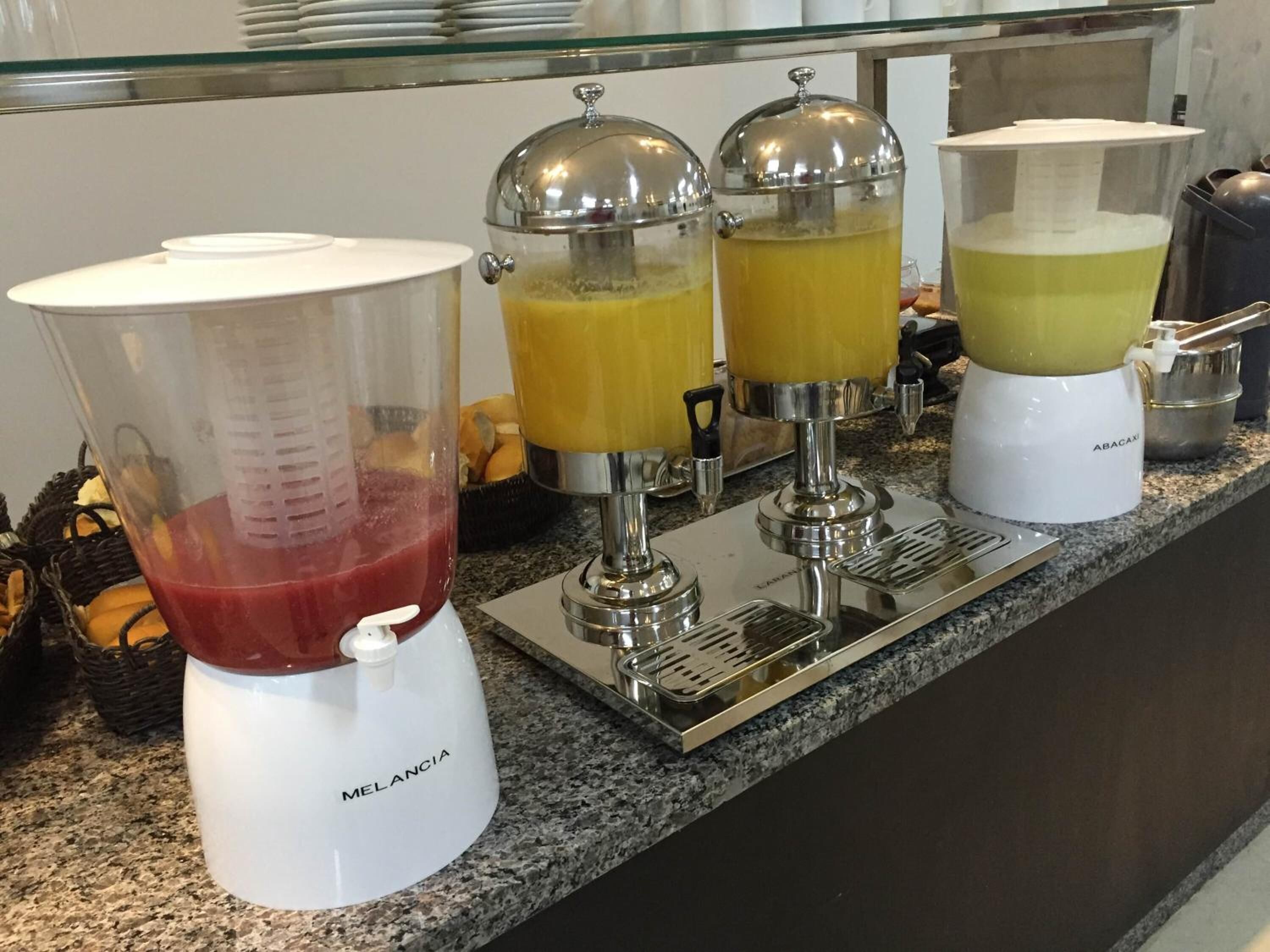 A kitchen counter with a blender, two juicers, and a coffee maker.
