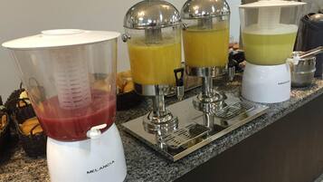 A kitchen counter with a blender, two juicers, and a coffee maker.